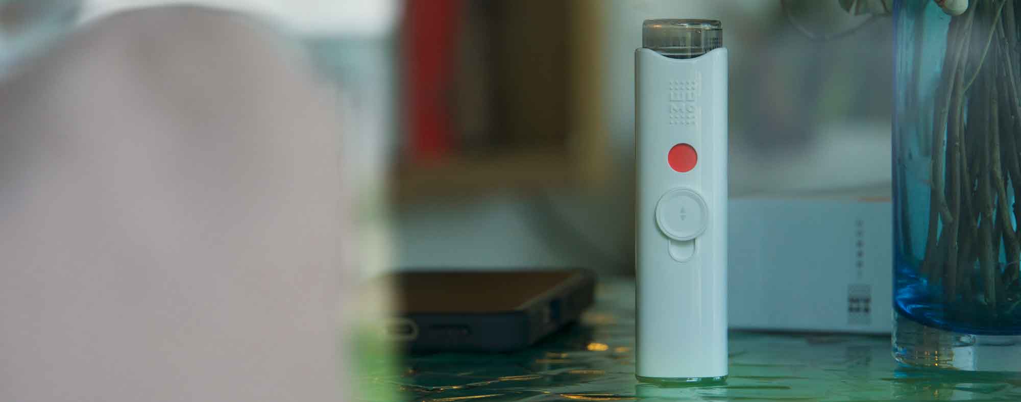 Eine Person, die sicher in ihrem Auto geparkt ist und einen Wumo-Eye-Hydrator benutzt, um die Augen zu erfrischen, bevor sie ihre Reise fortsetzt